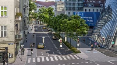 Rendering der Aspernbrückengasse von Aspernbrücke. Spuren von links nach rechts: Gehsteig, Radweg (stadteinwärts), 2 Fahrspuren (stadteinwärts), 1 Fahrspur (stadtauswärts), Grünstreifen mit Bäumen, Zweirichtungsradweg, Gehsteig. ZOOMVP/Mobag